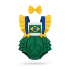 Bebê menina vestindo jardineira brasil tricoline verde amarelo bandeira VAI DAR BRASIL — torcedora Copa 2026