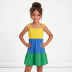 Menina vestindo vestido infantil alças laço tricolor verde azul amarelo brasil — look Copa 2026 VAI DAR BRASIL encanto